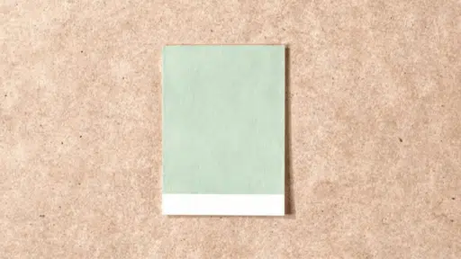 escape gray paint sample card placed on a wooden table, showing soft neutral color for home