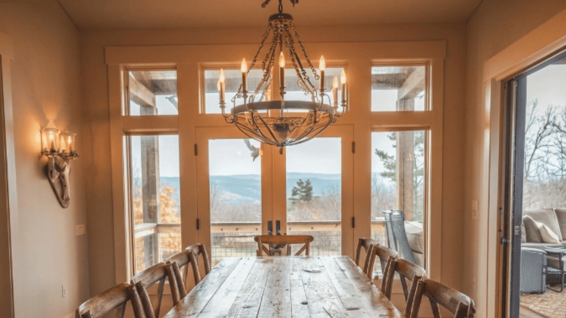 farmhouse chandelier with wood and metal above dining table in cozy space