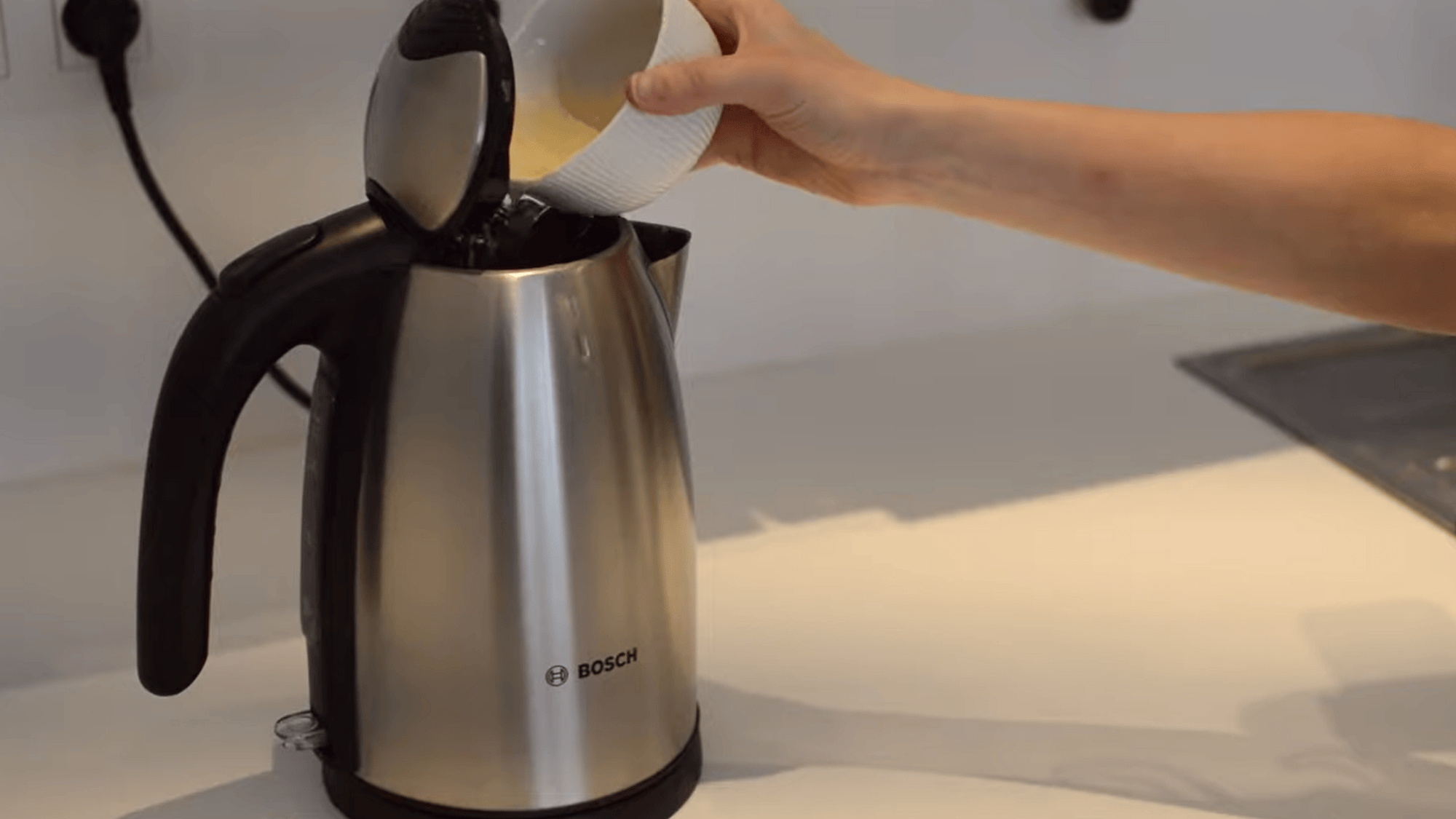 filling electric kettle with vinegar and water mixture