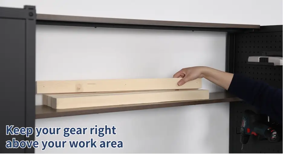 Hand placing wooden planks on black metal shelf above power drill in workshop