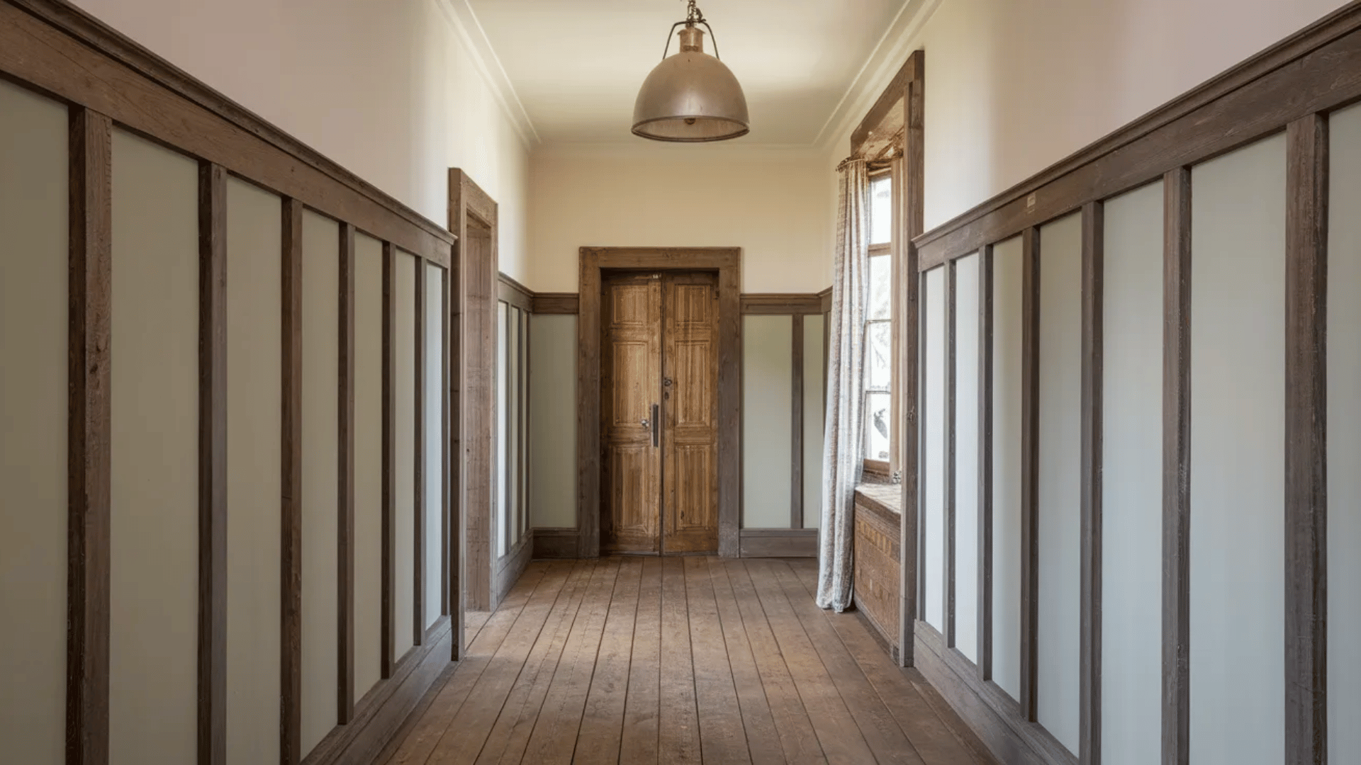 hallway with wood paneling, a wooden door, and natural light from a window