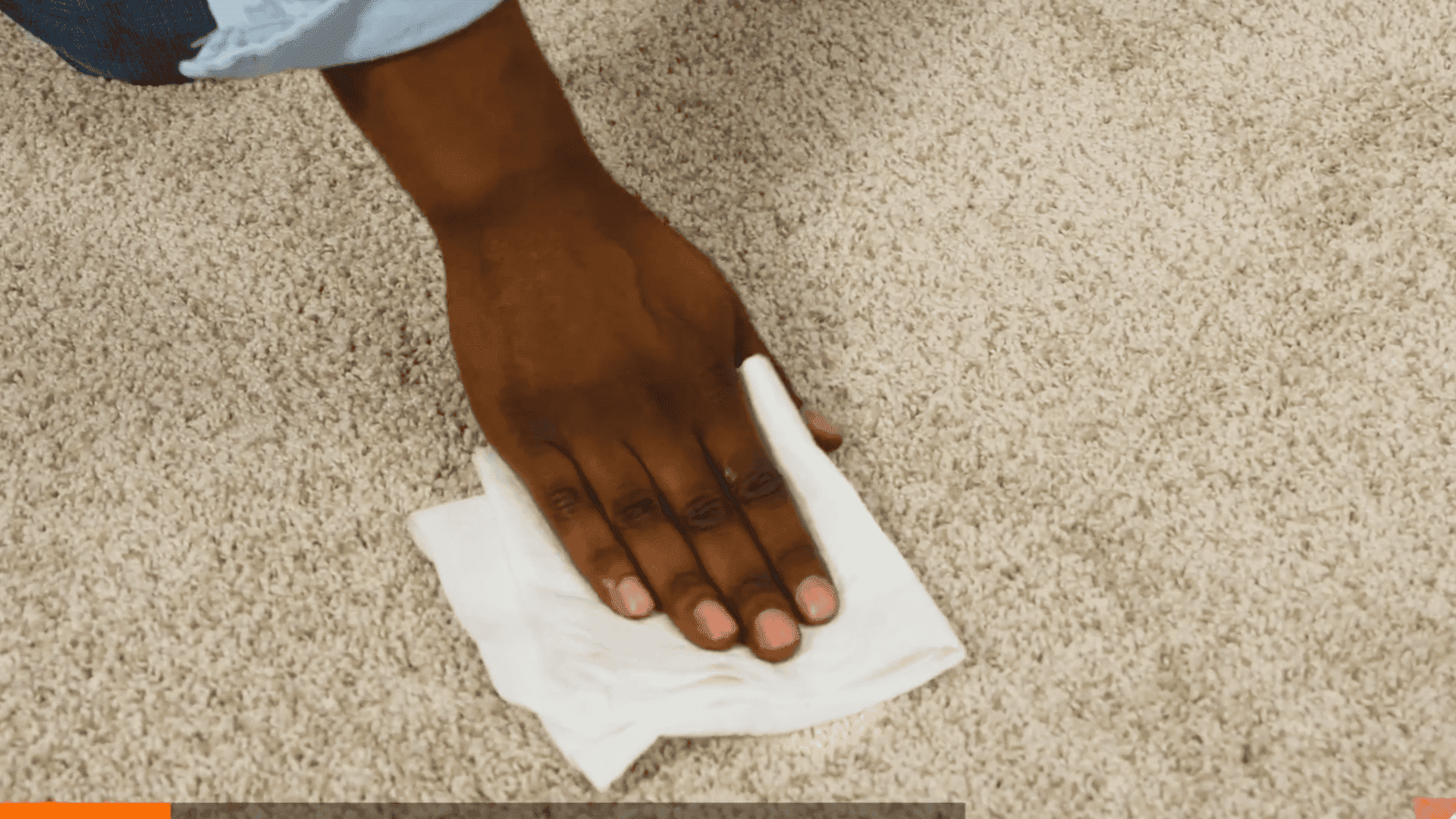 hand blotting fresh paint stain on carpet using a clean white cloth without scrubbing