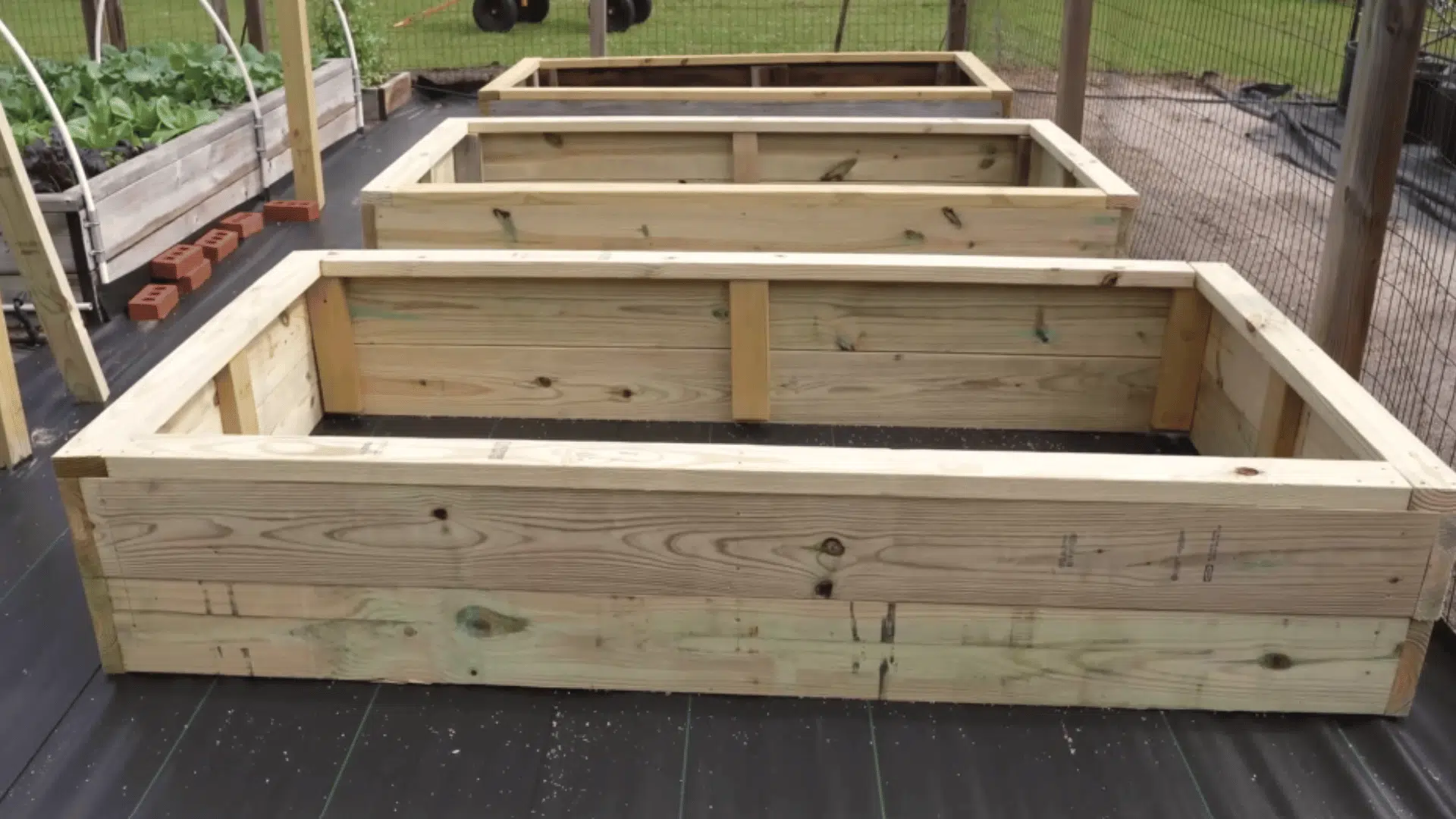 installed top railings on raised garden bed for seating support