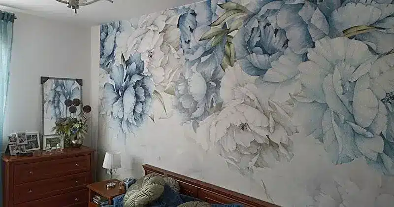 Floral wallpaper with blue and white peonies in a bright bedroom with wooden furniture