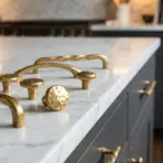 Brass cabinet handles on white marble countertop in modern kitchen setting