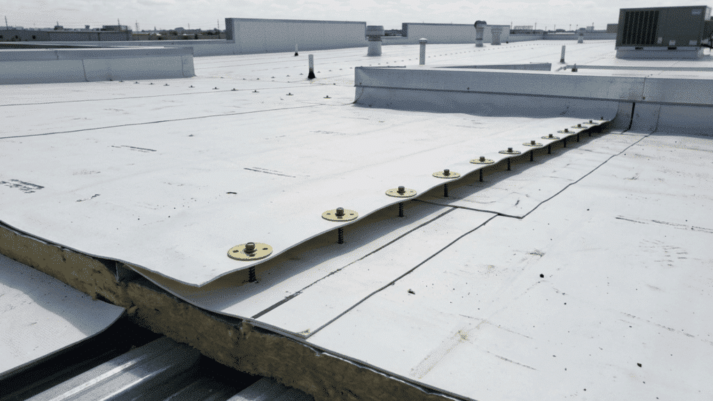 mechanically attached tpo roofing system with screws and plates on flat commercial roof showing membrane installation detail