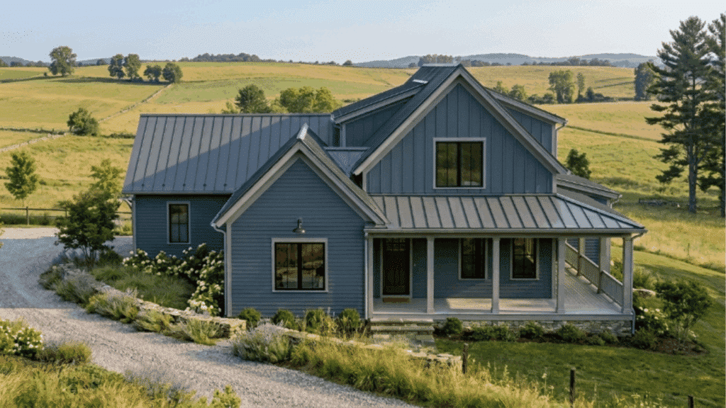 modern farmhouse with slate blue siding gray trim metal roof wooden porch countryside morning fog exterior