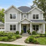 modern suburban house with soft gray siding white trim navy front door landscaped yard bright daylight showing curb appeal exterior design