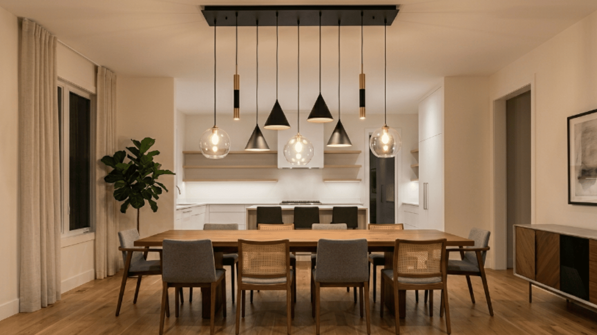 multiple pendant lights at different heights above empty dining table with layered lighting