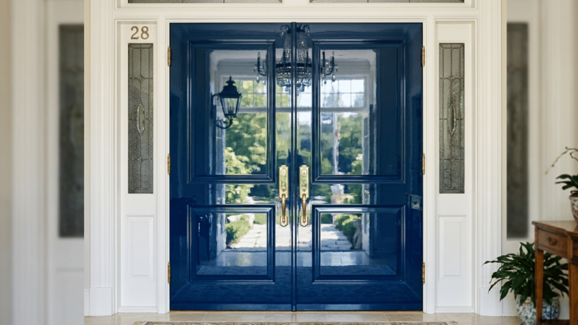 navy blue high gloss double doors with gold hardware and white trim in a bright entryway