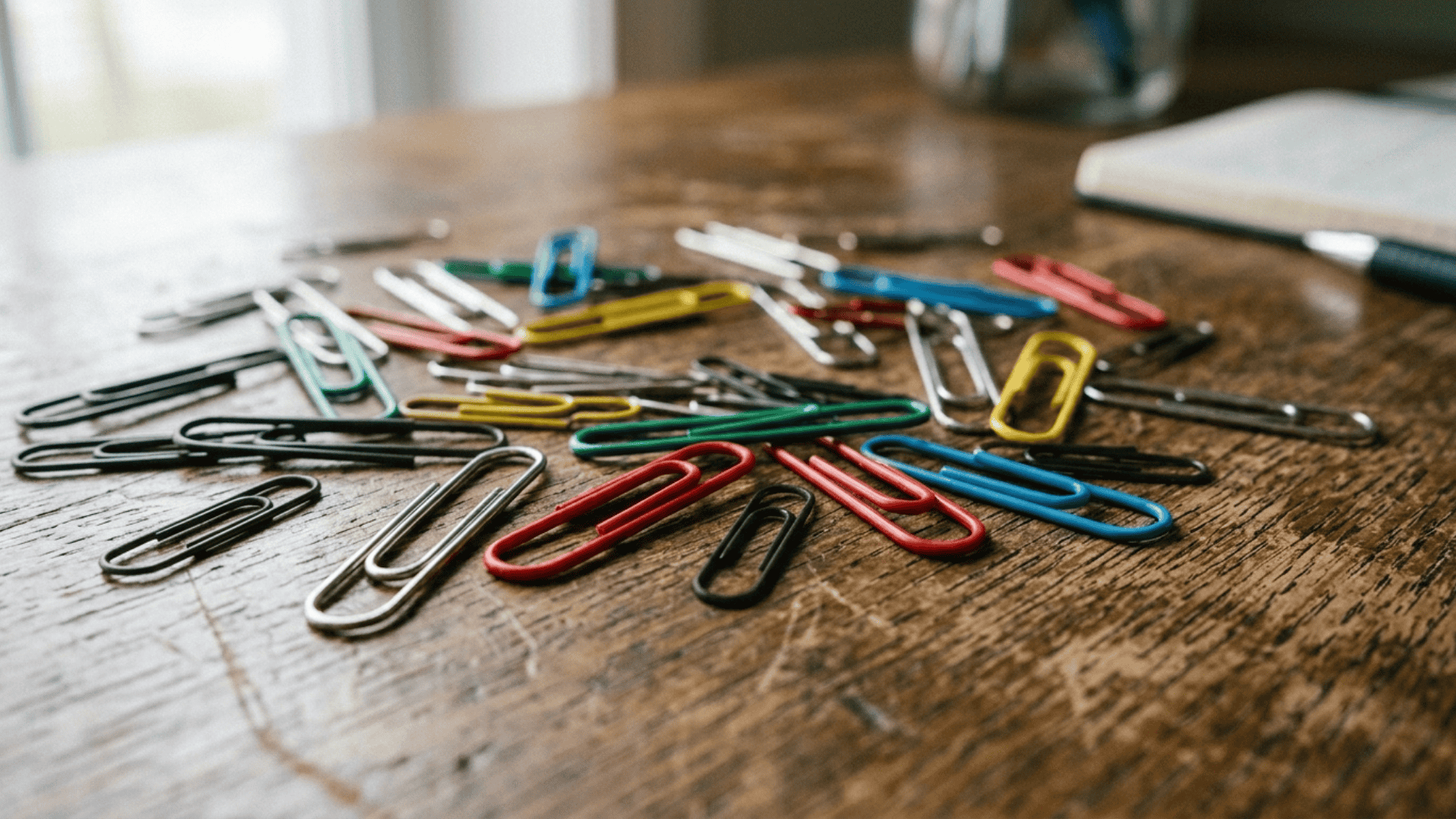 paper clips made of steel and coated materials placed on desk showing different types and finishes used in manufacturing