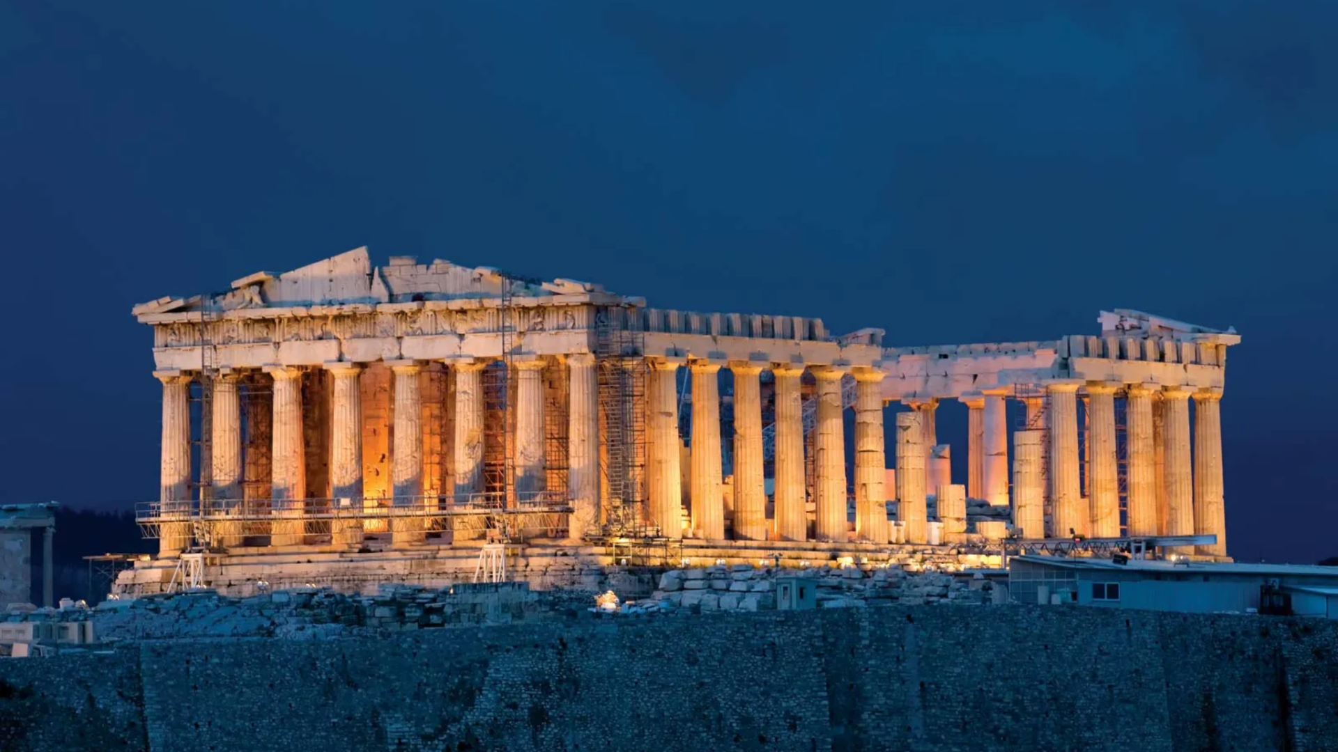 parthenon in Athens lit at dusk, showing classical Greek columns and symmetry, a key example of early european architecture. (1)