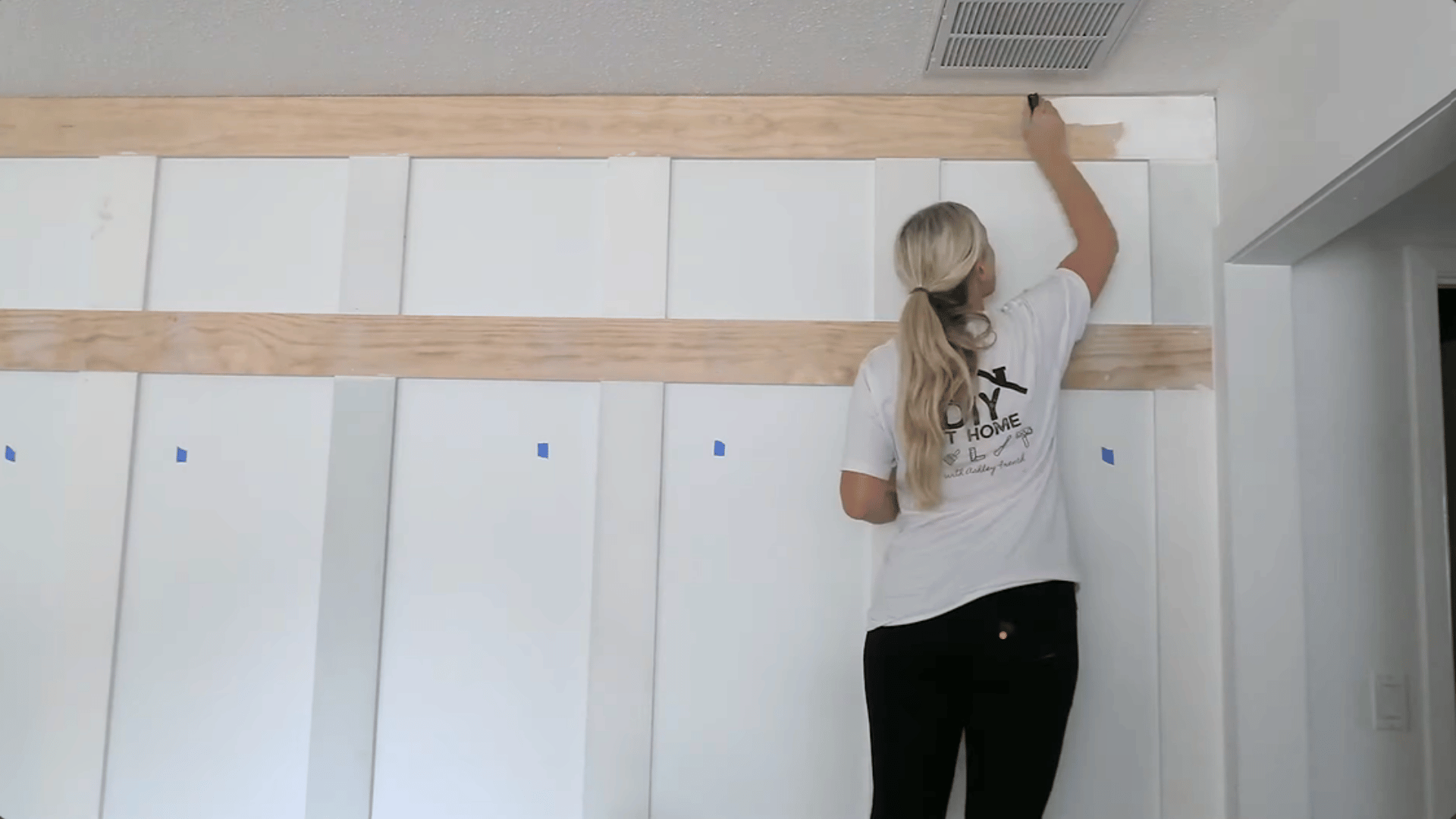 person applying wood filler to the seam of a wooden board on the wall (1)