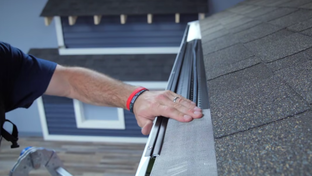 positioning gutter guard over heat cable on roof edge.