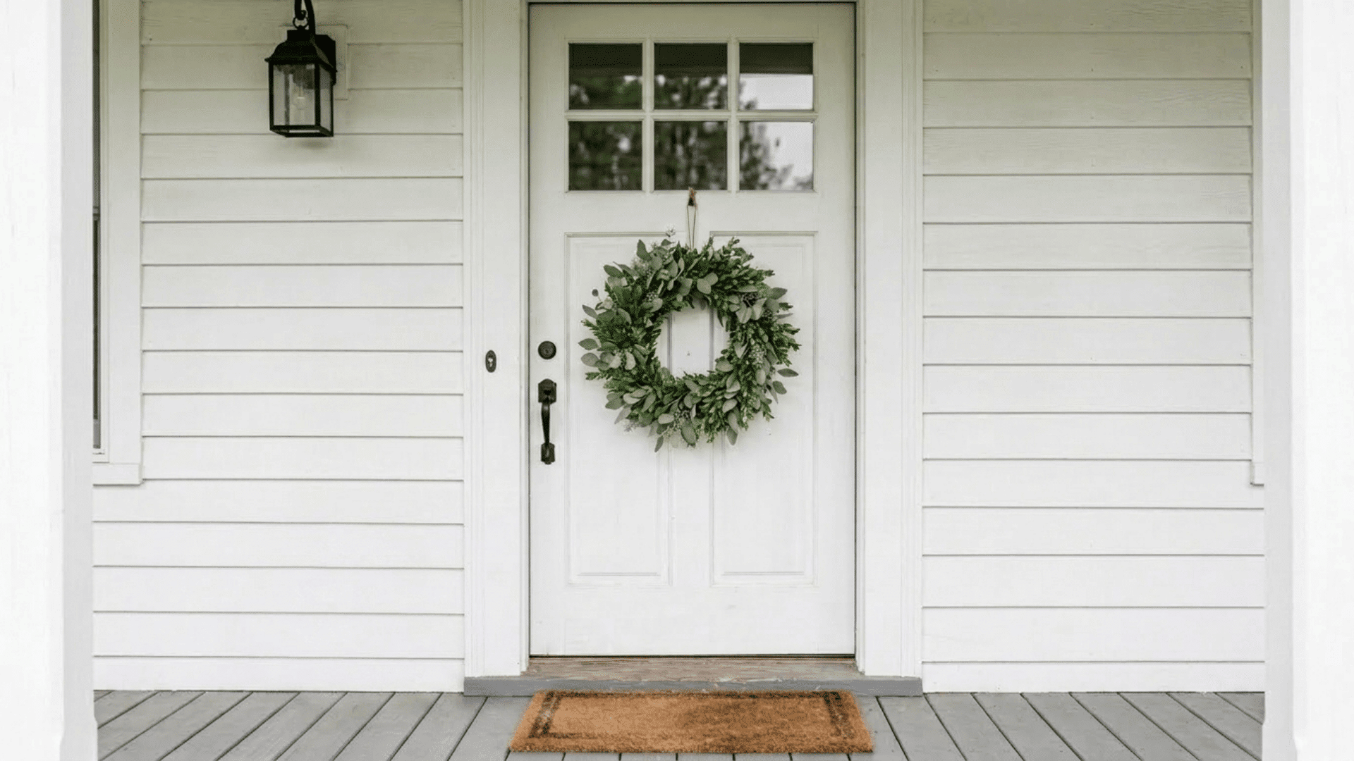 simple eucalyptus and boxwood greenery wreath on a white farmhouse front door in natural light