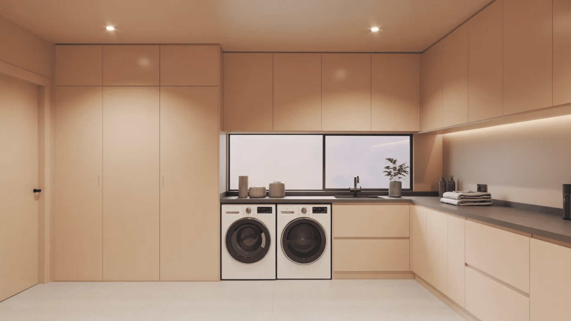 simple laundry room with beige cabinets, washer and dryer, and clean uncluttered design