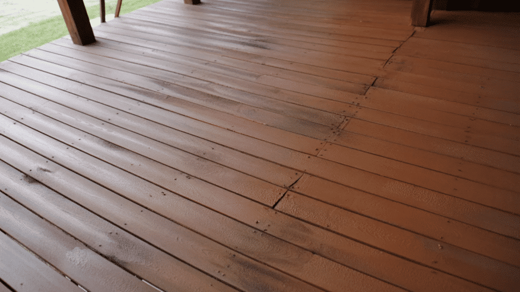 solid-stained deck with uniform color covering worn boards and cracks