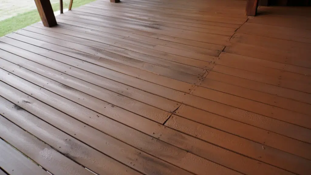 solid-stained deck with uniform color covering worn boards and cracks