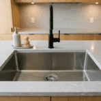 stainless steel undermount kitchen sink with clean empty basin and black faucet on modern countertop