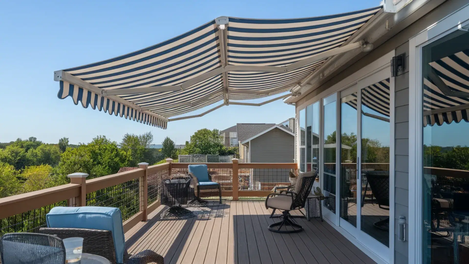 striped retractable awning provides shade on a deck, offering a cozy outdoor seating area with comfortable chairs and a beautiful view