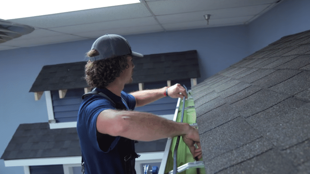 technician placing heat cable along roof edge near gutter.