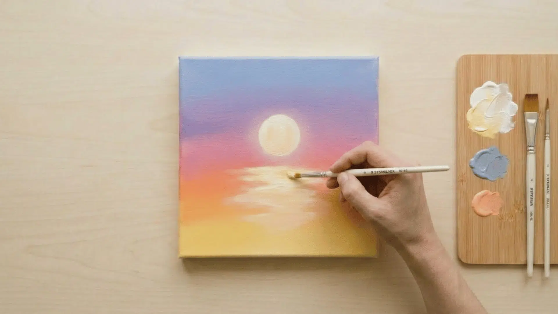 top view of hand blending water reflection in sunset painting with soft brush strokes