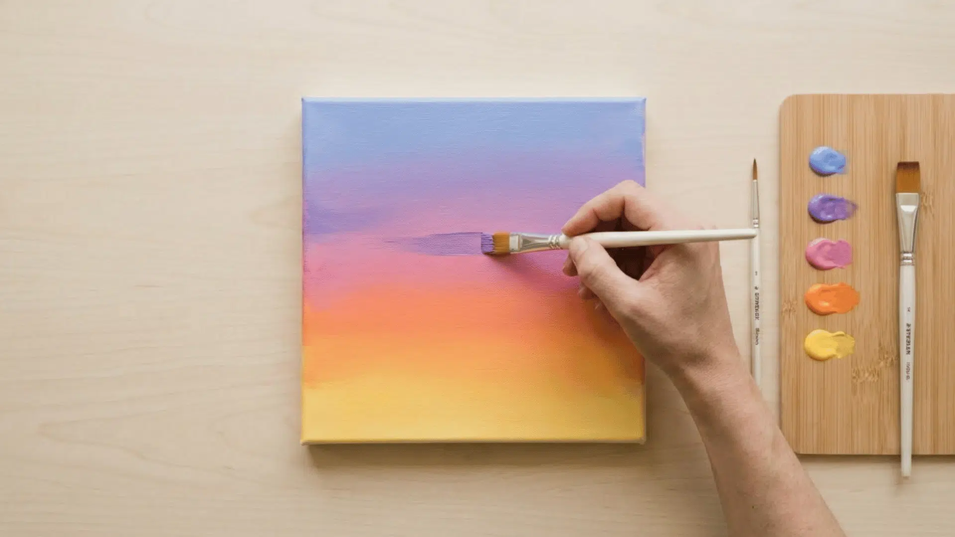 top view of hand painting sky gradient with acrylic colors on canvas with palette on side