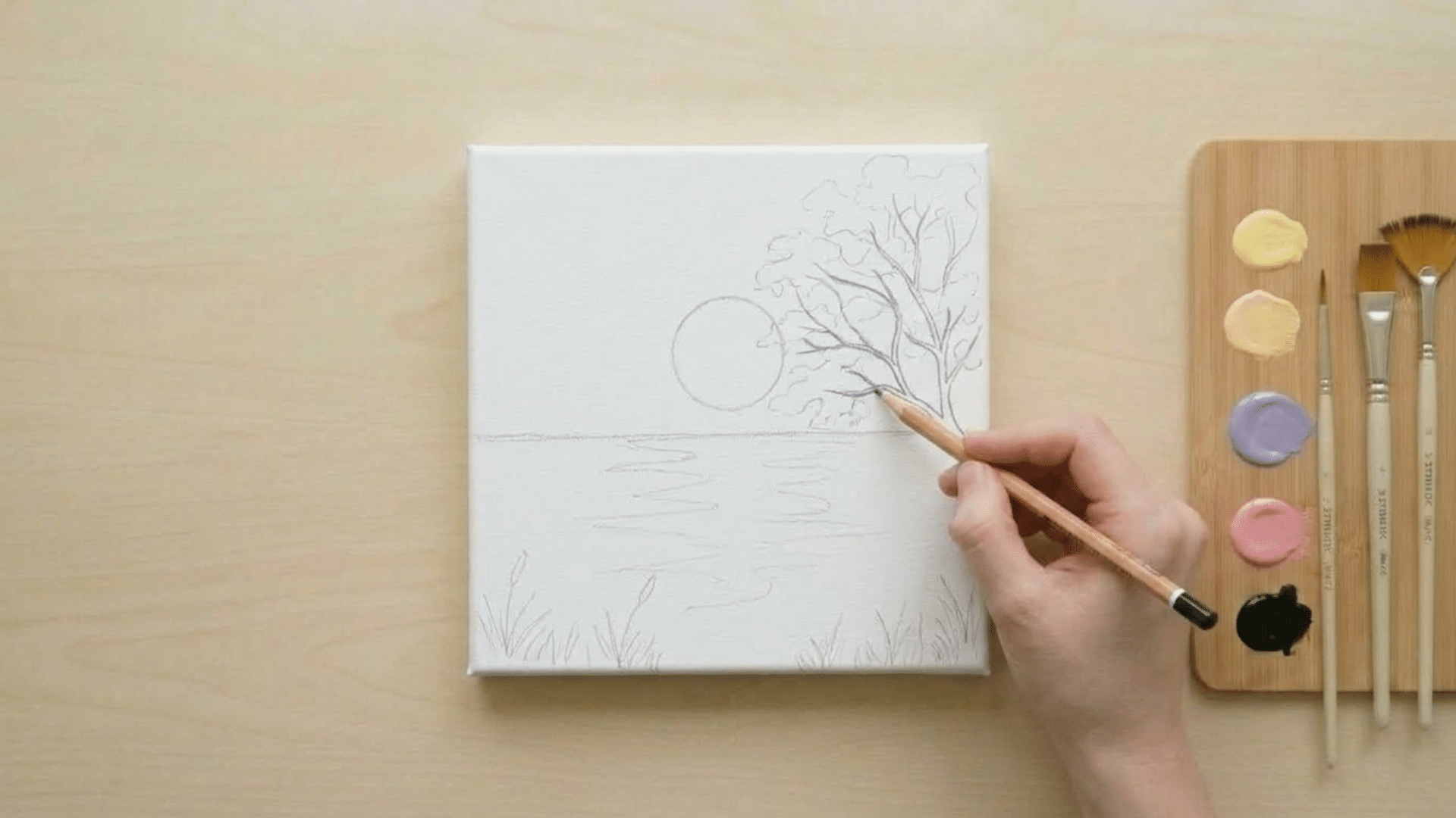 top view of hand sketching sunset outline on canvas with pencil and eraser on clean table