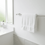 towel bar mounted at the correct height on a white bathroom wall with a folded white towel