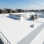 white tpo roofing system on a large flat commercial building with hvac units and solar panels installed