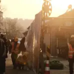 Construction workers in reflective vests and helmets in sunlit urban alleyway