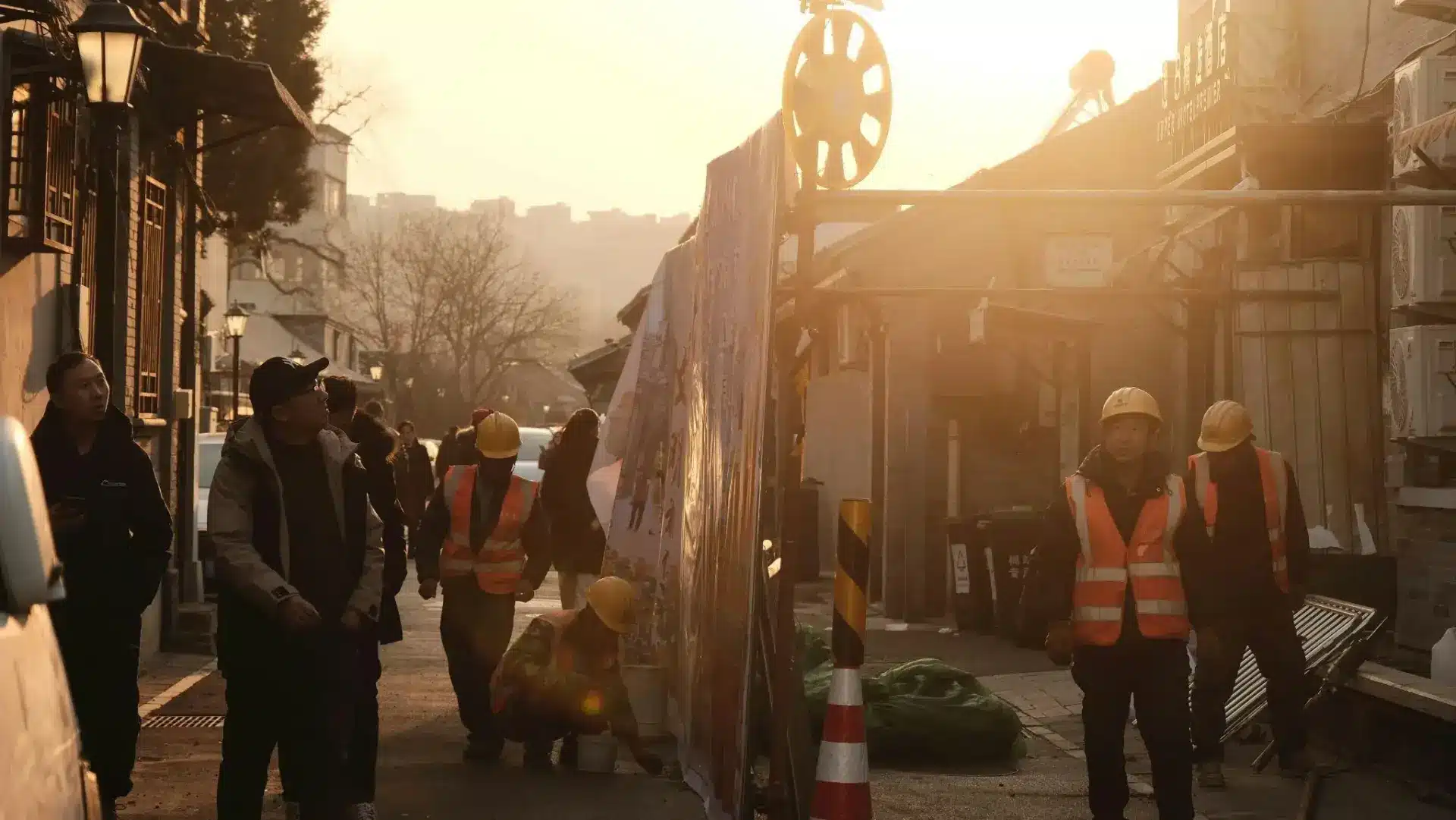 Construction workers in reflective vests and helmets in sunlit urban alleyway