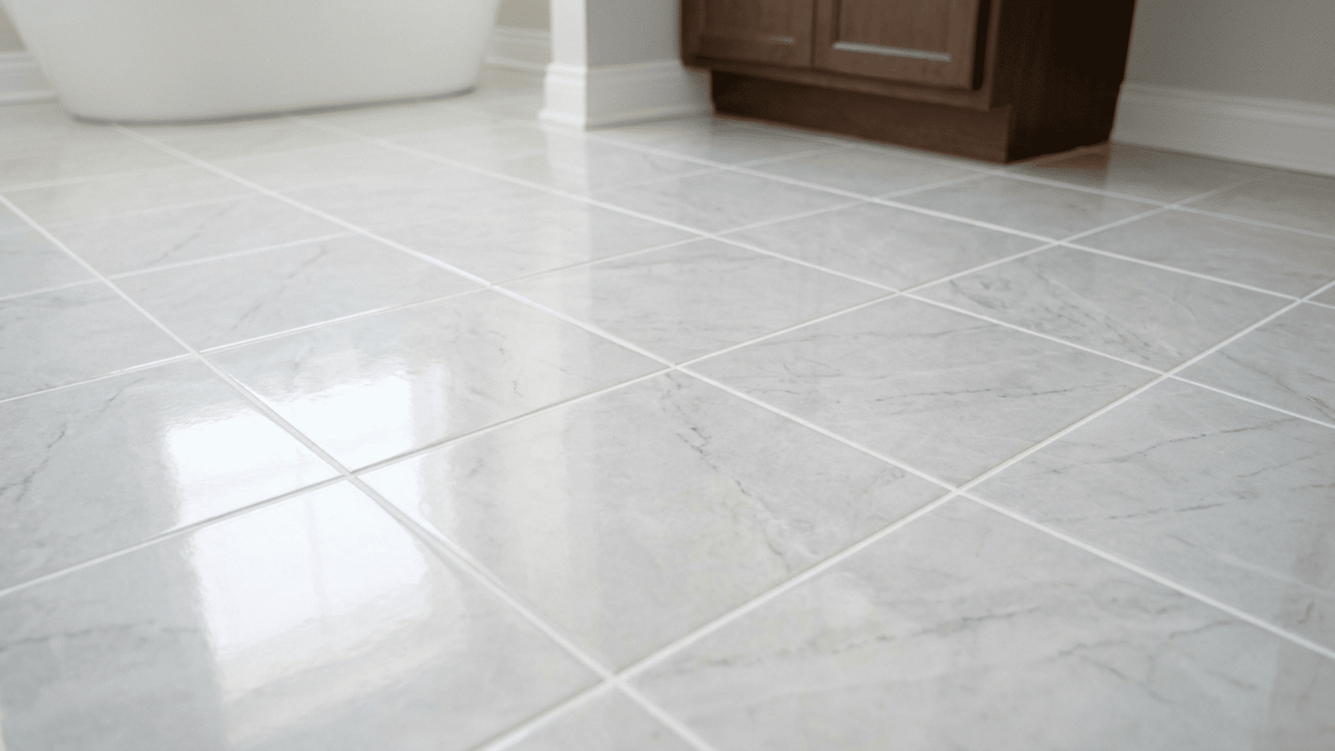clean bathroom floor tiles with freshly sealed bright white grout lines reflecting soft bathroom lighting