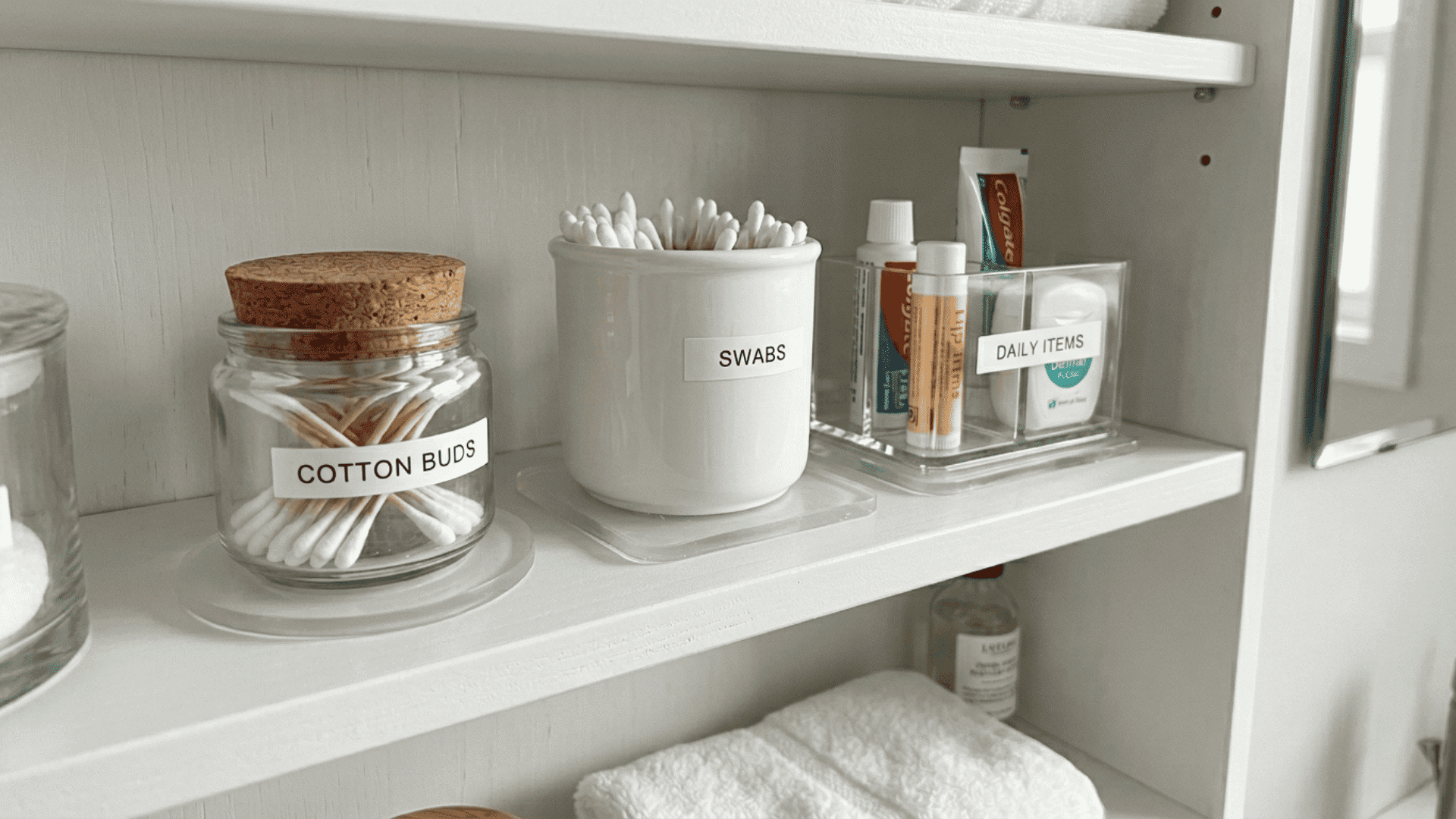clear non-slip gel pads placed under small bathroom containers and bins on a white cabinet shelf