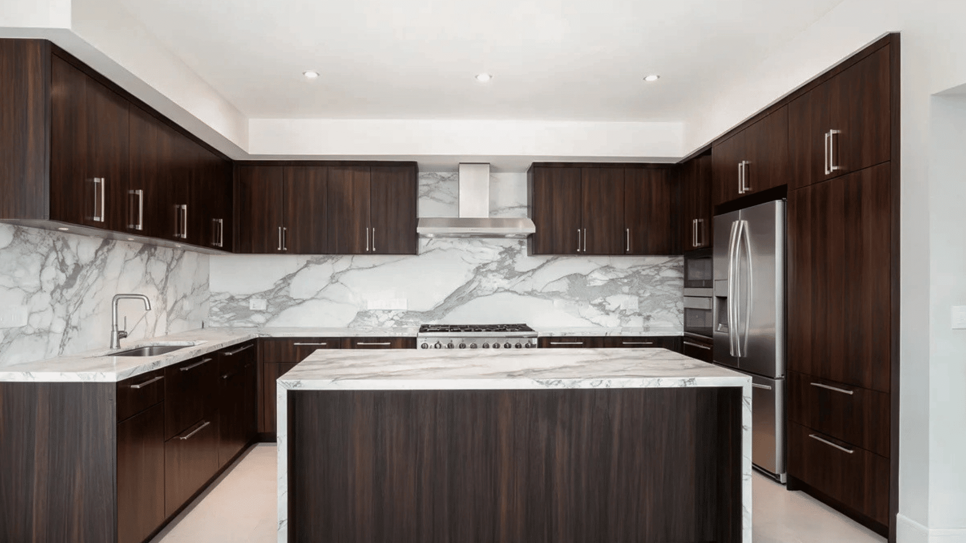 contemporary kitchen with dark wooden cabinets marble countertops and island