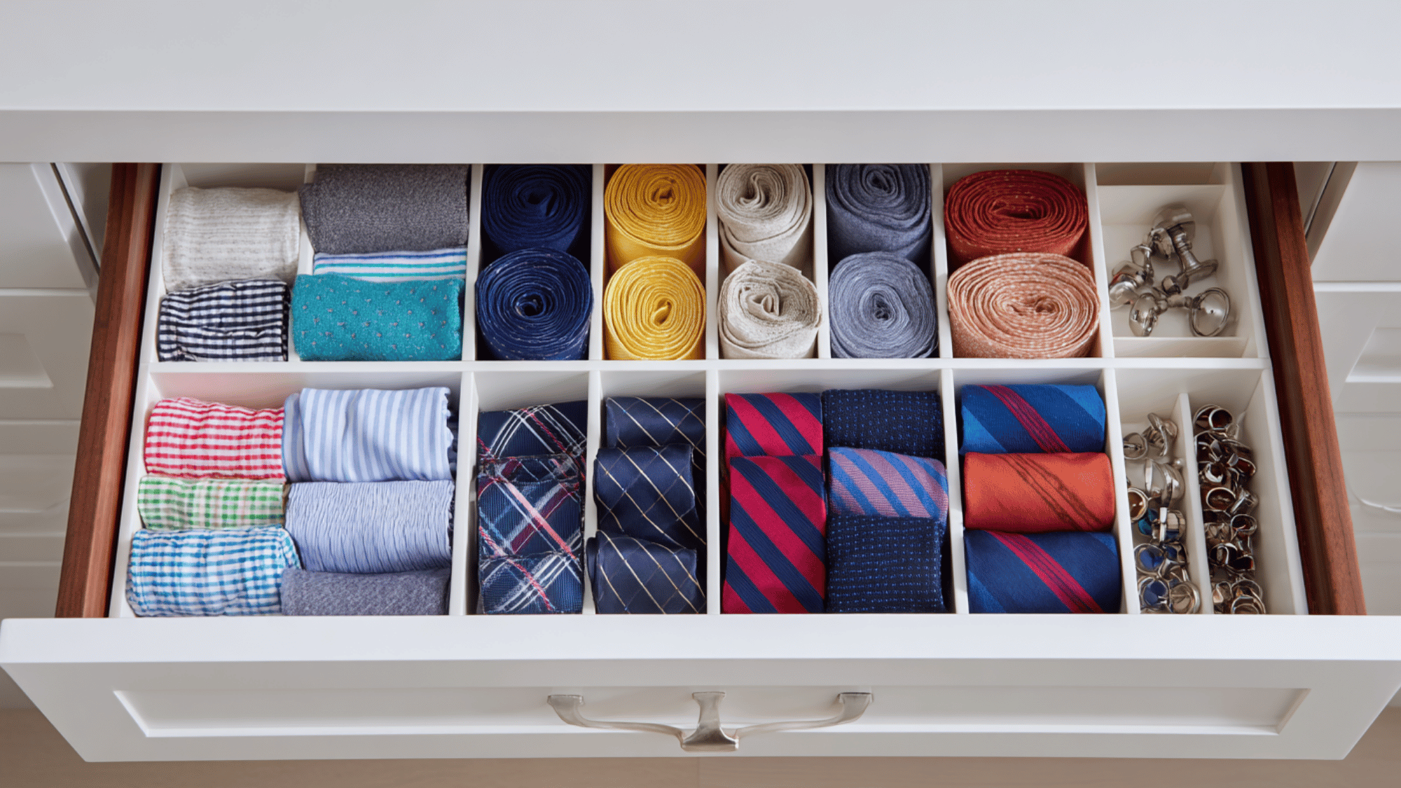 drawer dividers inside a closet drawer creating organized compartments for socks, accessories, and undergarments in a small closet.