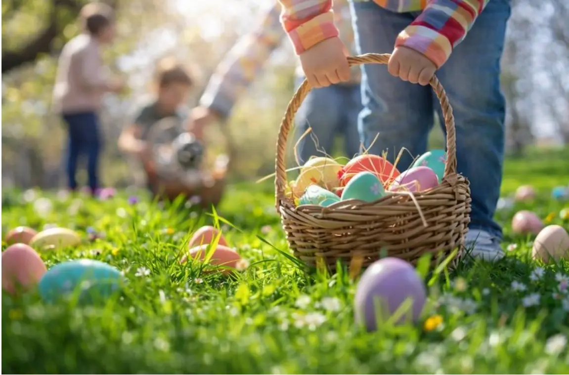 Child holding basket of colorful Easter eggs in sunny grassy field