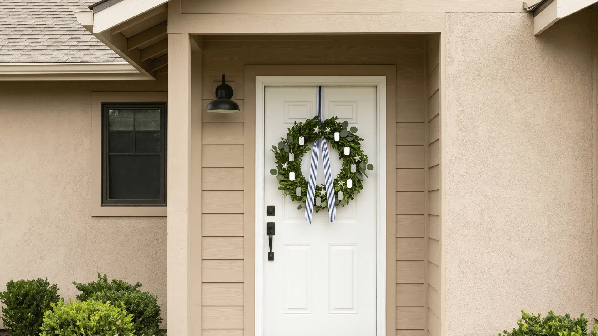 front view greenery wreath with metallic dog tags and star accents on a neutral door (1)