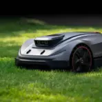 Robotic lawn mower on green grass in sunny outdoor setting