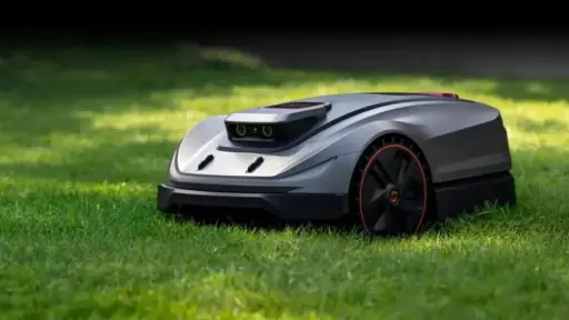 Robotic lawn mower on green grass in sunny outdoor setting