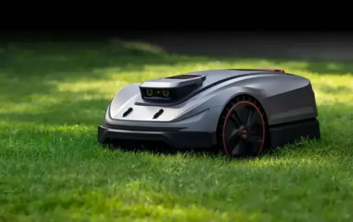 Robotic lawn mower on green grass in sunny outdoor setting