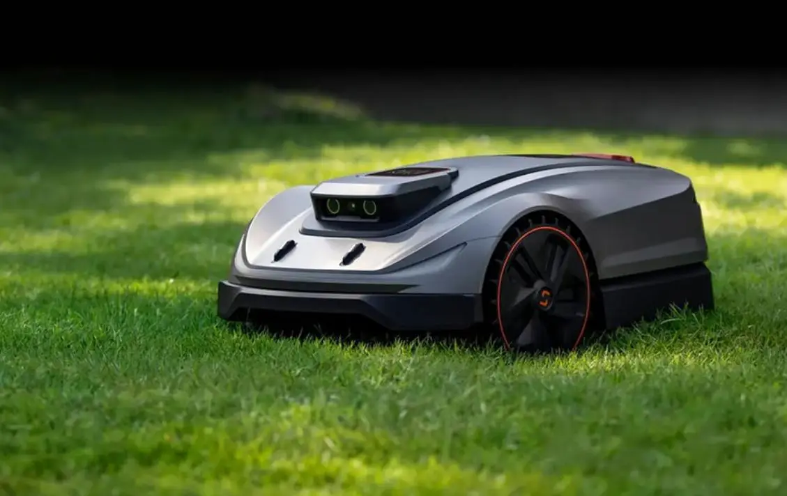 Robotic lawn mower on green grass in sunny outdoor setting