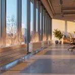 Modern office interior with desks and ergonomic chairs in natural light from large windows