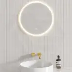 Circular LED mirror above sleek white basin with gold fixtures in modern bathroom