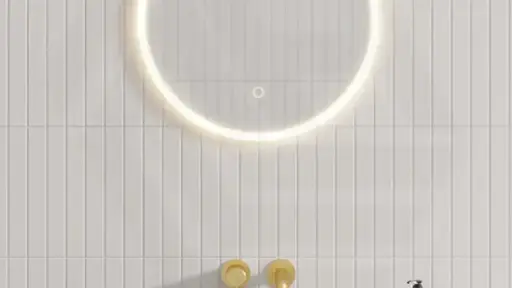 Circular LED mirror above sleek white basin with gold fixtures in modern bathroom