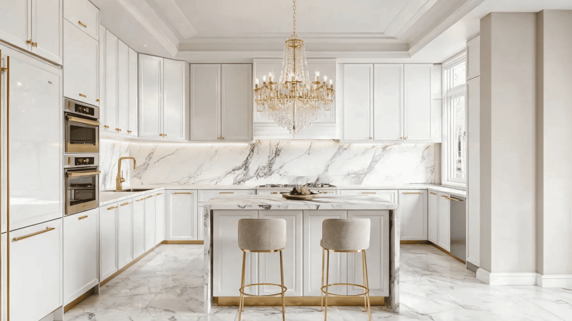 luxurious white kitchen with marble countertops gold fixtures and chandelier