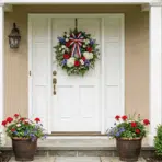 memorial day wreath with red white and blue flowers hanging on a white front door of a house