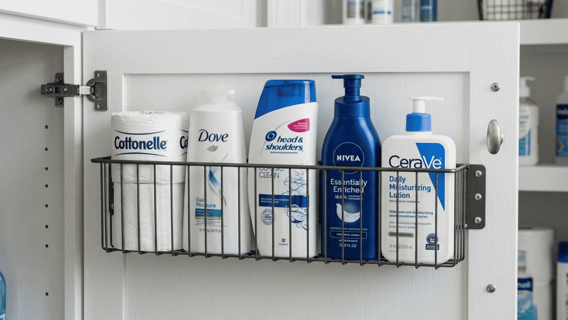 slim wire basket mounted on the inside of a bathroom cabinet door having backup shampoo and large lotion bottles