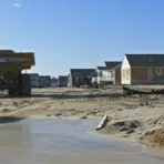 Construction site with unfinished houses and large dump truck under clear blue sky