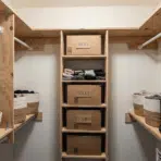a walk in closet with wooden shelves and baskets organizing socks and tshirts in labeled storage boxes